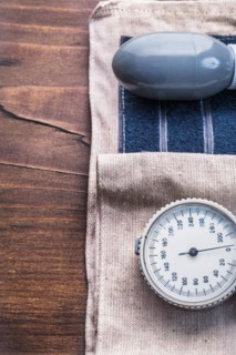 Blood pressure monitor on vintage wooden board close up medical concept