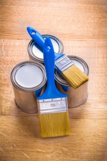 Composition of two brushes and three tins on a wooden board