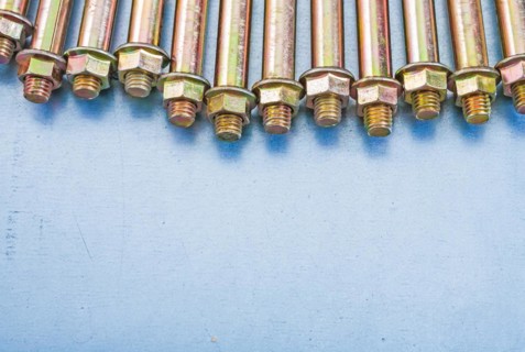 Copy space image Anchor bolts for concrete walls and nuts on metallic background Construction concept