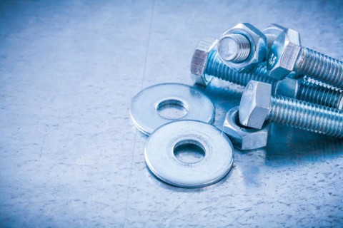 Metal threaded bolts nuts and bolts washers on metallic background copy space image construction concept
