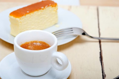 Italian espresso coffee and cheese cake over white wood table