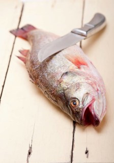Fresh whole raw fish on a wooden table ready to cook