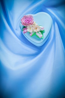 Heart-shaped gift box on blue fabric background celebrations concept