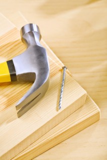 Hammer and nail on wooden boards
