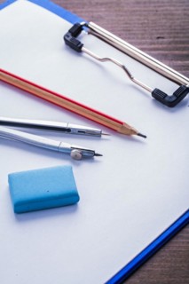 Pencil Eraser Compass and clipboard with paper on vintage wooden board Learning concept