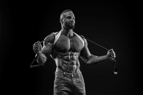 Silhouette of a strong bodybuilder. Confident young fitness athlete with a powerful body and perfect abs. Black and white photography. Dramatic light. Mixed media