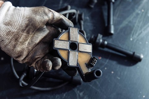 Engine ignition coil in hand of auto mechanic