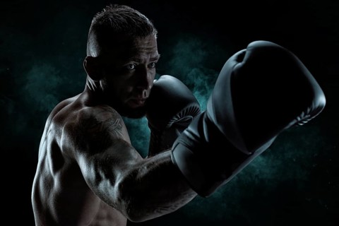 Kickboxer in black gloves posing on a background of smoke. The concept of mixed martial arts. MMA