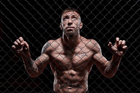 Dramatic image of a mixed martial arts fighter standing in an octagon cage. Powerful abdominal muscles. The concept of sports