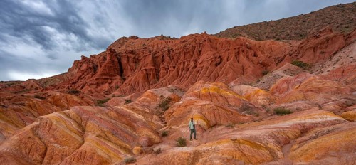 Tourist hikes through canyon of eroded sandstone formations