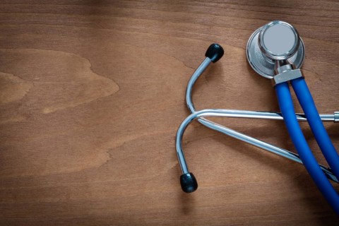 Horizontal view of stethoscope for medical examination on pine vintage wooden board medicine concept