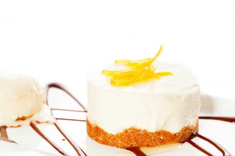 Very elegant lemon mousse dessert served whith lemon peel on top and vanilla ice cream on side