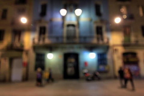 Passers-by in front of illuminated house facade at night