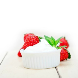 Organic Greek yogurt and strawberry over white rustic wood table