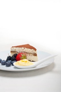 Classic Italian tiramisu dessert with berries and custartd pastry cream on side