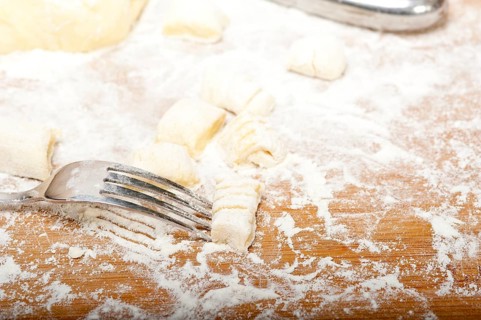 Making fresh Italian potato gnocchi on a wood rustic table