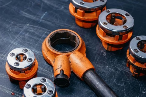 Professional tool for plumber locksmith for threading sewer metal and plastic pipes. A set of klups
