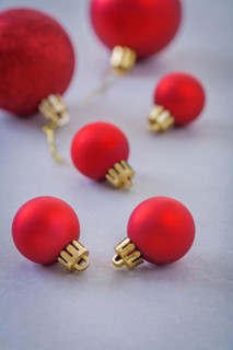 Composition of small and big red christmas balls on grey background
