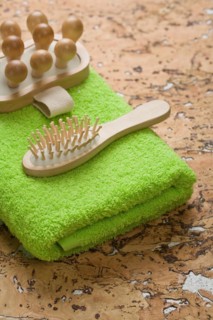 Massager and hairbrush on a green towel