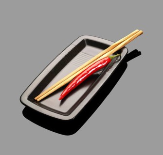 Fresh red chili peppers on a plate with chopstikcs over grey reflective surface