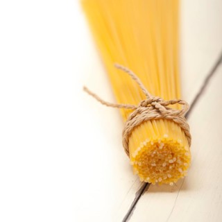 Italian pasta spaghetti tied with a rope on a rustic table