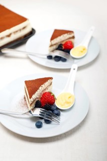 Classic Italian tiramisu dessert with berries and custartd pastry cream on side