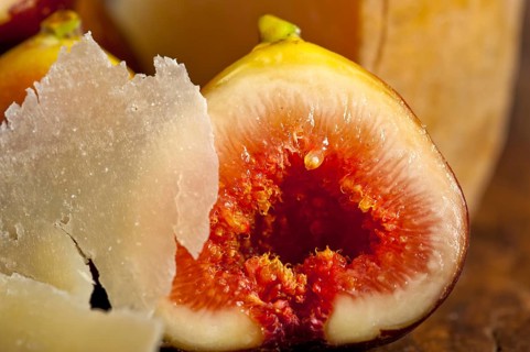 Italian pecorino cheese and fresh figs macro closeup over old wood boards