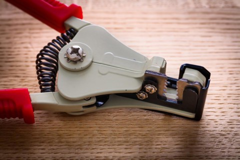 Close-up of an automatic wire stripper on a wooden board