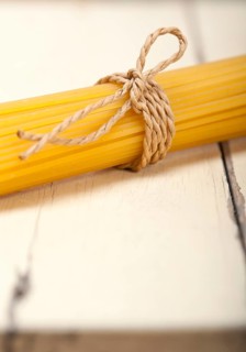 Italian pasta spaghetti tied with a rope on a rustic table