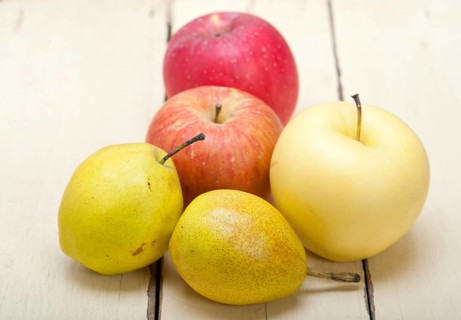 Fresh fruits apples and pears on a white wood table