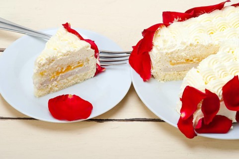 Whipped cream mango cake with red rose petals