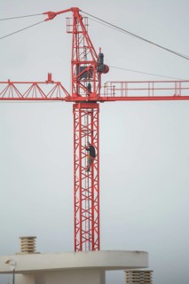 Professional crane operator inspecting the crane at high altitude