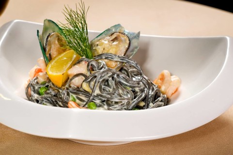 Fresh seafood black squid ink coulored spaghetti pasta tipycal italian food