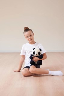 Cute girl child posing in the studio with a soft toy in a light studio. The concept of education