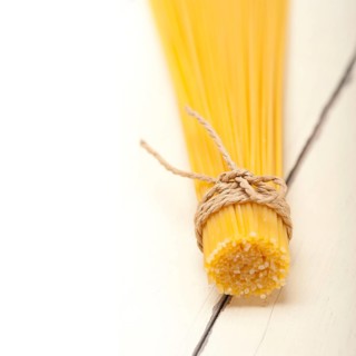 Italian pasta spaghetti tied with a rope on a rustic table