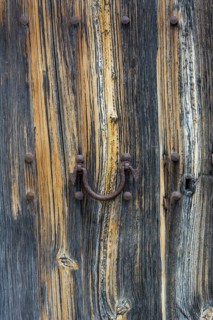 Old wooden door with aged metal door handle. Architectural textured background