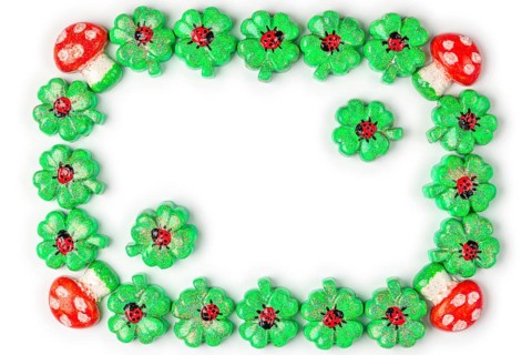 A frame of shamrocks with ladybirds and toadstools