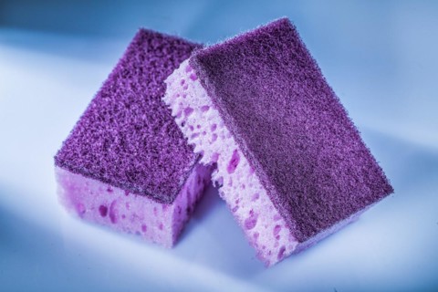 New violet kitchen sponges on white surface