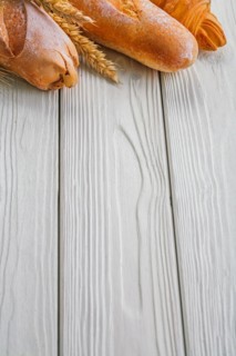 Copyspace image baguettes and ears of wheat rye on vintage wooden painted boards food and drink concept