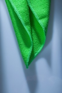 Green kitchen dishwashing cloth on white background