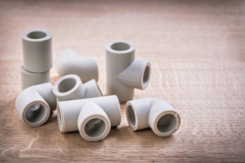 Set of polypropylene pipe fittings on wooden board