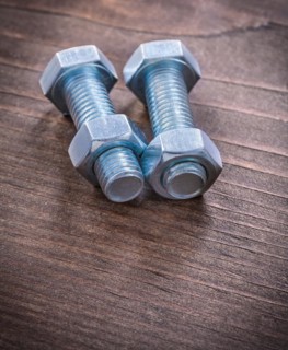 Steel stainless steel threaded bolts and nuts on vintage brown wooden board repair concept