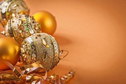 Composition of golden Christmas baubles on a light brown background