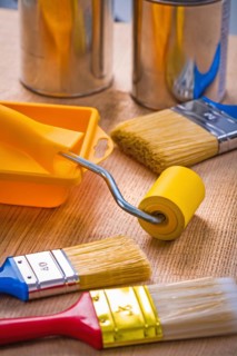 Large set of painting tools on wooden board Brushes Roller Tray Tins