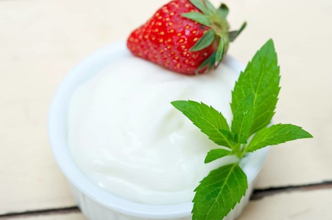 Organic Greek yogurt and strawberry over white rustic wood table
