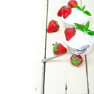 Organic Greek yogurt and strawberry over white rustic wood table