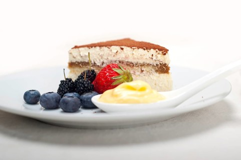 Classic Italian tiramisu dessert with berries and custartd pastry cream on side