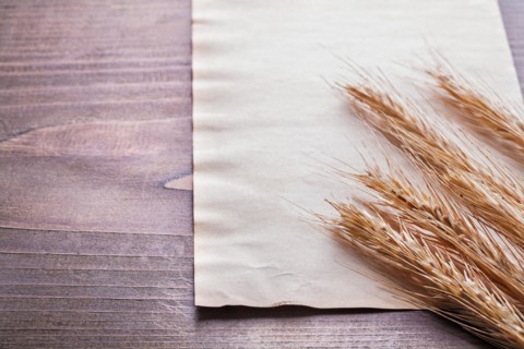 Ears of wheat on vintage blanc paper and old wooden board food and drink concept