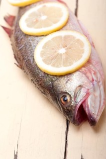 Fresh whole raw fish on a wooden table ready to cook