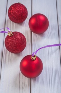 Composition of red Christmas baubles on white lacquered plates